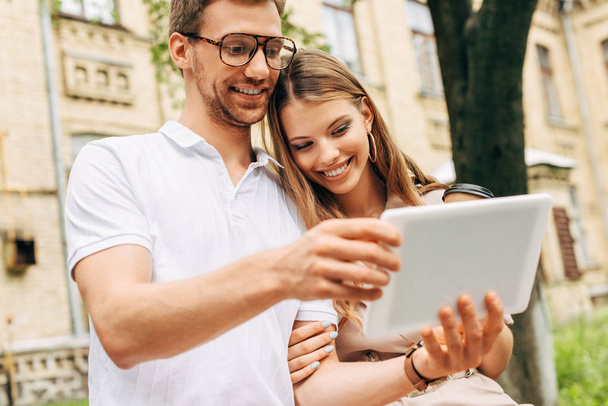 happy young couple using tablet together near old building - Photo, Image