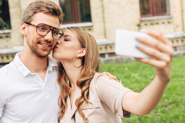 beautiful young couple taking selfie while spending time together near old building - Photo, Image