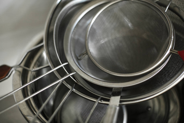 set of metal black pans and pots and colander on kitchen - Фото, изображение
