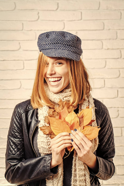 Girl with orange leaves at brick wall. - Photo, Image