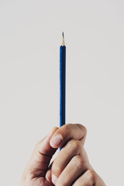 Closeup mladý bělošský pravák člověka s zostření tužku v ruce, proti bílé pozadí. - Fotografie, Obrázek
