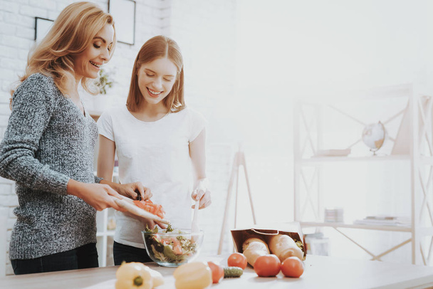 Smiling Mother and Daughter Cooking Together in Kitchen. Relationship in Family. Holiday at Home. Healthy Food and Lifestyle Concept. Cooking Together. Happiness in Family Concept. - Foto, Bild