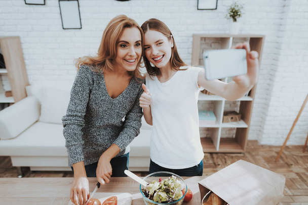 Smiling Mother and Daughter Taking Selfie in Kitchen. Relationship in Family. Holiday at Home. Healthy Food and Lifestyle Concept. Cooking Together. Happiness in Family Concept. Taking Photo. - Fotografie, Obrázek