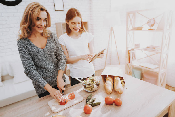 Smiling Mother and Daughter Cooking Together in Kitchen. Relationship in Family. Holiday at Home. Healthy Food and Lifestyle Concept. Cooking Together. Happiness in Family Concept. - Foto, imagen
