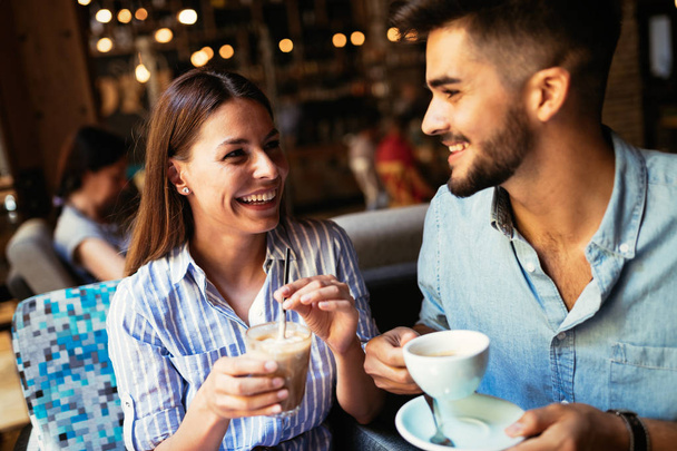 Young attractive cheerful couple on date in coffee shop - Φωτογραφία, εικόνα
