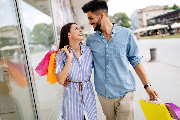Ευτυχισμένο ζευγάρι ελκυστική αγαπώντας απολαμβάνουν τις δαπάνες φορά για ψώνια μαζί - Φωτογραφία, εικόνα