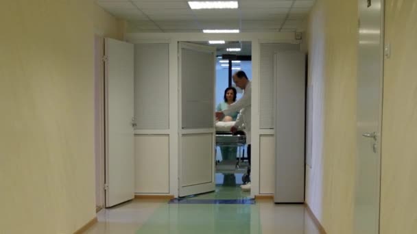 Arzt und Krankenschwester fahren im Buggy in den Operationssaal des Krankenhauses. - Filmmaterial, Video