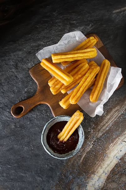 Traditional Mexican dessert churros with chocolate sauce. Dark background - Foto, Bild