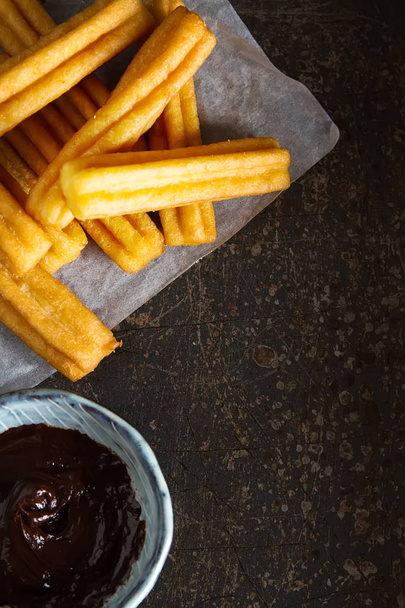 Traditional Mexican dessert churros with chocolate sauce. Dark background - Foto, Imagen