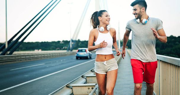 Athletic couple jogging in nature in good spirit - Фото, зображення