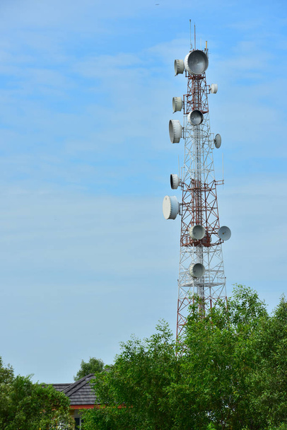 Bezprzewodowa komunikacja anteny z jasnego nieba. Wieża telekomunikacyjna z anteny z błękitnego nieba. - Zdjęcie, obraz