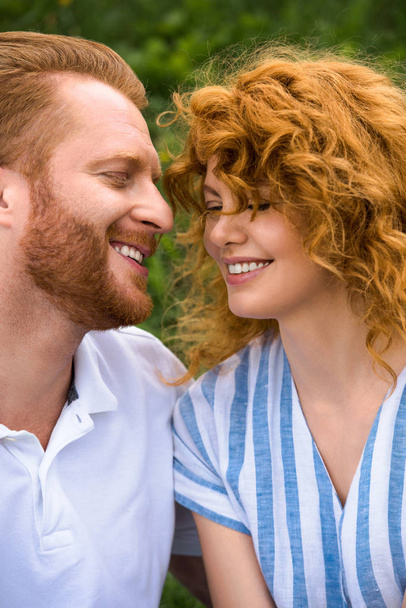 portrait of happy redhead couple with closed eyes outdoors  - Foto, afbeelding