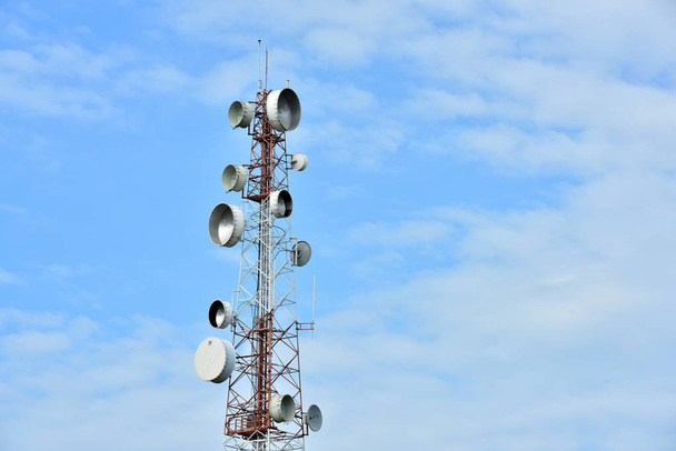 Antena de comunicación inalámbrica con cielo brillante.Torre de telecomunicaciones con antenas con cielo azul
. - Foto, imagen