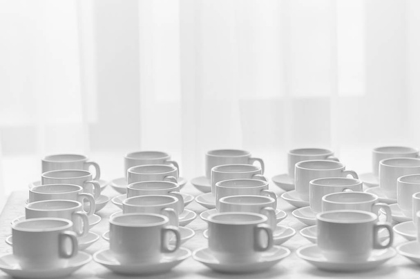 White cups for tea  stacked in line on table with tablecloth for coffee-break - Foto, Imagem