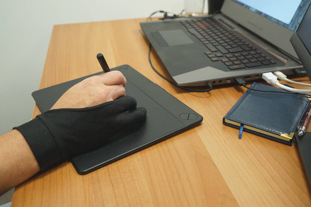 Mies suunnittelija freelancer käyttää grafiikka tabletti kosketusnäyttö ja kynä toimistossa
 - Valokuva, kuva