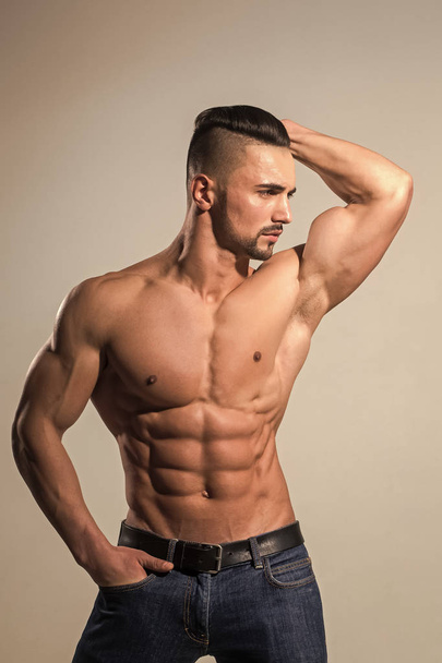 Athletic bodybuilder man on grey background. Dieting and fitness. - Zdjęcie, obraz