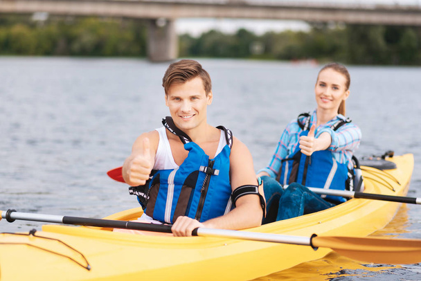 Blue-eyed man enjoying memorable river ride with girlfriend - Foto, imagen