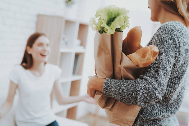 Mother with Packs of Food from Store at Home. Daughter Helping Mother. Healthy Food and Lifestyle Concept. Cooking Together. Bread in Bag. Mother and Daughter at Home. Teenage Girl. - Фото, зображення