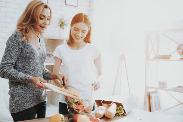 Smiling Mother and Daughter Cooking Together in Kitchen. Relationship in Family. Holiday at Home. Healthy Food and Lifestyle Concept. Cooking Together. Happiness in Family Concept. - 写真・画像