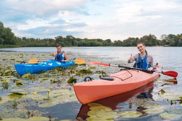 Smiling couple feeling satisfied after active river ride in canoe - Fotografie, Obrázek