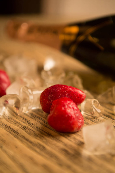 Champagne bottle on the tabe with ice and strawberry - 写真・画像