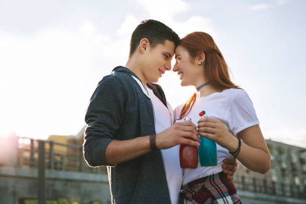 Positive young people holding their drinks Romantic date. - Фото, изображение