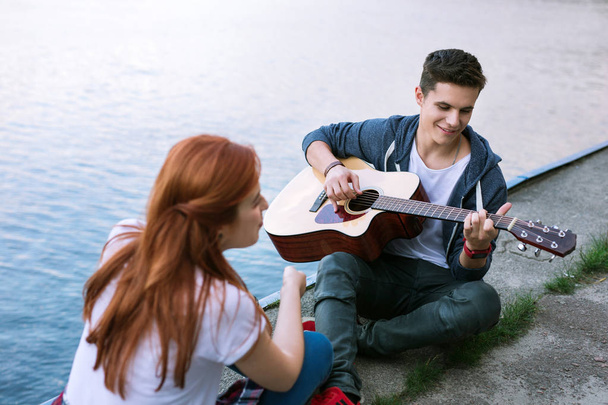 Positive joyful man playing the guitar Romantic date. - Foto, imagen