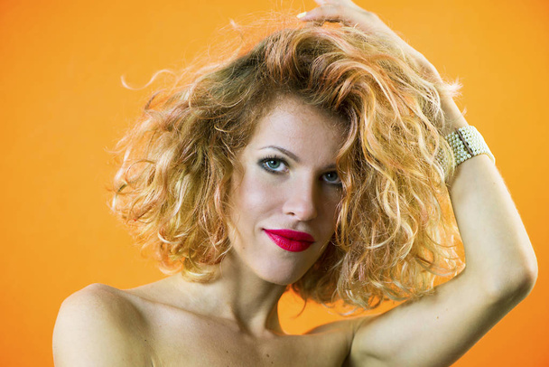 face of a pretty girl with curly hair and red lips closeup - Фото, изображение