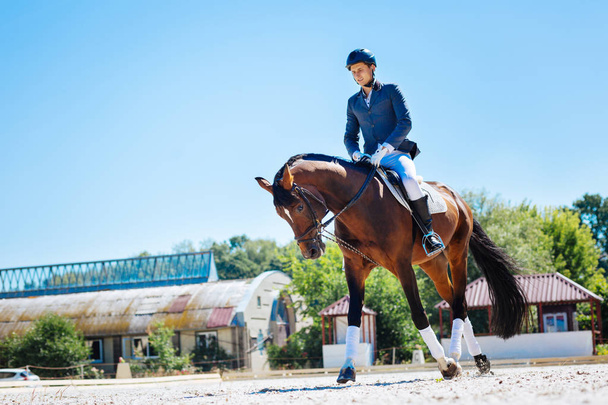 Young promising equestrian feeling exhausted after training - 写真・画像