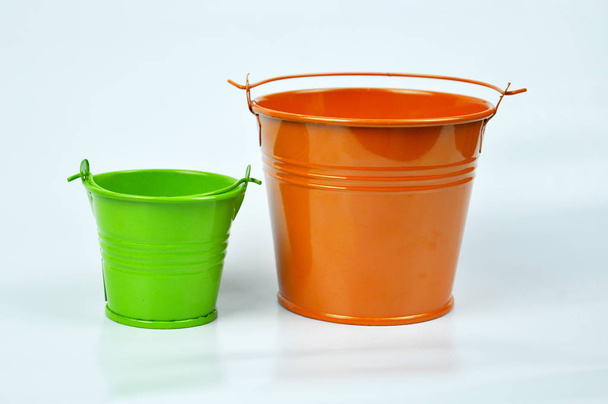 Small orange and green buckets isolated on white background. - Photo, Image