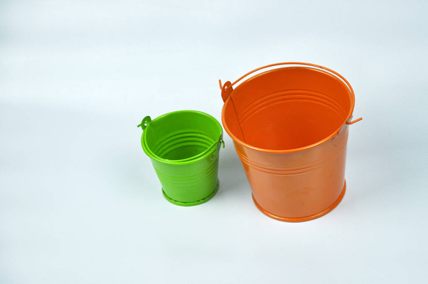 Pequenos baldes laranja e verde isolados no fundo branco
. - Foto, Imagem