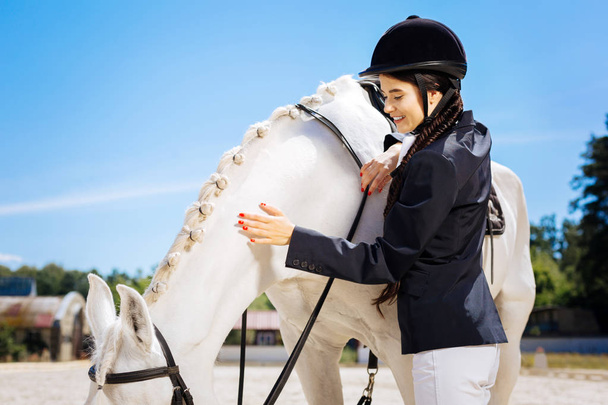 Appealing female rider wearing white trousers and dark jacket - Photo, Image