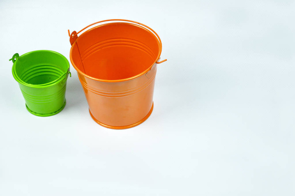 Pequenos baldes laranja e verde isolados no fundo branco
. - Foto, Imagem
