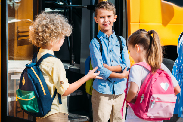 adorables élèves bavardant près du bus scolaire
 - Photo, image