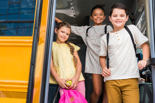 grupo de alumnos adorables de pie en el autobús escolar
 - Foto, Imagen
