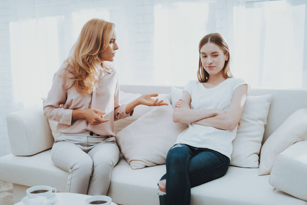 Quarrel between Mother and Daughter in White Room. Emotional Discussion. Sitting on Couch. Conflict in Family. Parent and Child. Unhappy Girl. Communication Concept. Relationship Problem. - 写真・画像