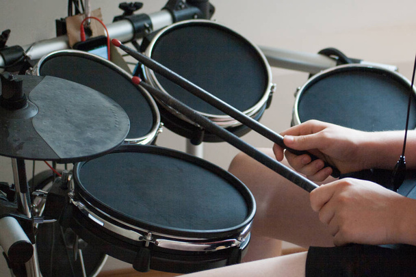 unrecognized boy practicing electronic drums with black drumsticks - Photo, Image