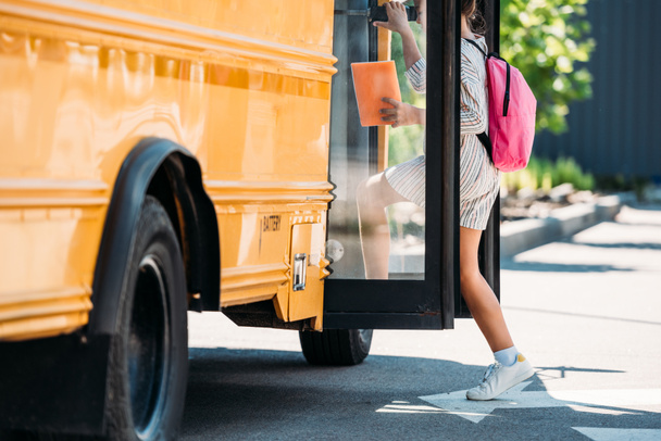 cropped shot of schoolgirl entering school bus - Фото, изображение