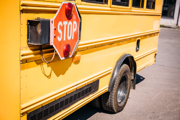 visão parcial do ônibus escolar com sinal de parada
 - Foto, Imagem