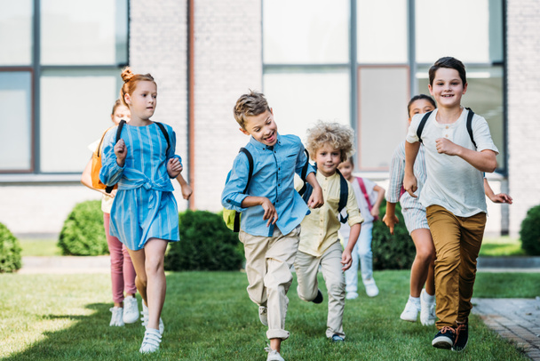 grupo de alumnos felices corriendo por el jardín escolar
 - Foto, Imagen