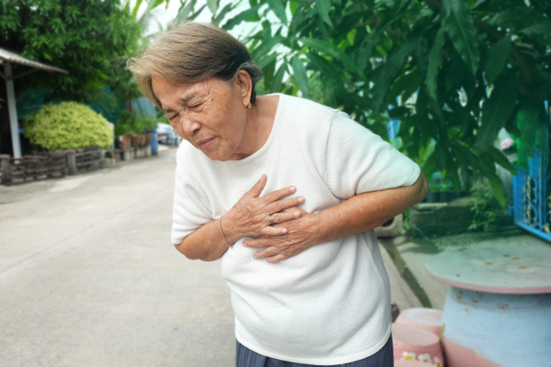 Літня Азіатська жінка з болем у грудях серцевий напад - Фото, зображення