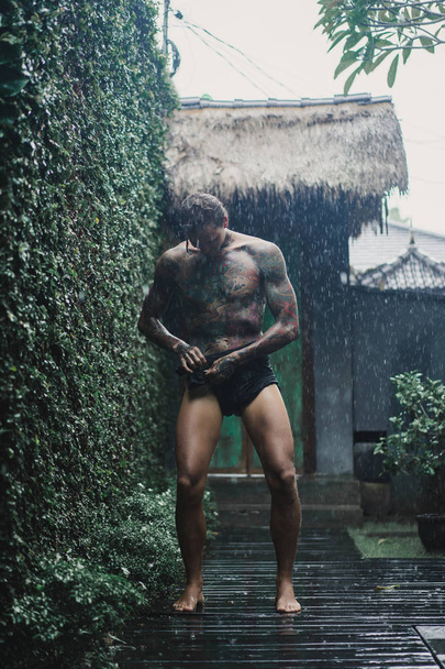young tattooed man posing in the rain - Zdjęcie, obraz
