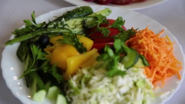 Salade met kruiden in een bord op de tafel. - Video