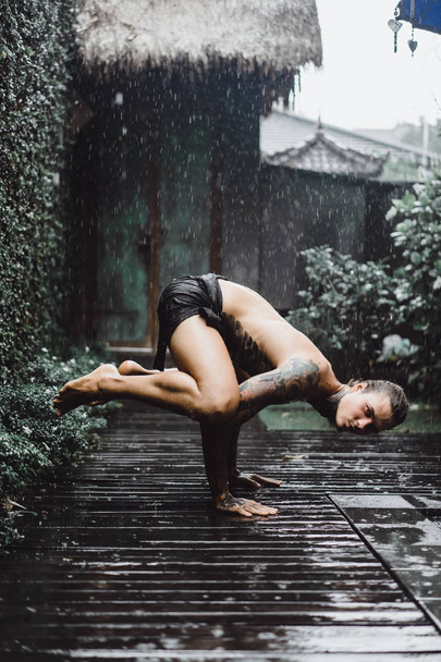 young tattooed man posing in the rain - Fotó, kép
