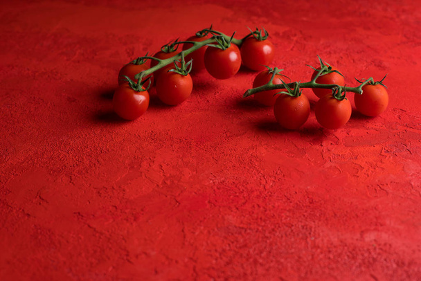 cherry tomatoes on red background - Фото, зображення