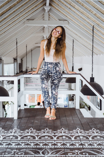 Beautiful brunette woman in loft home in tropical location. - Photo, Image