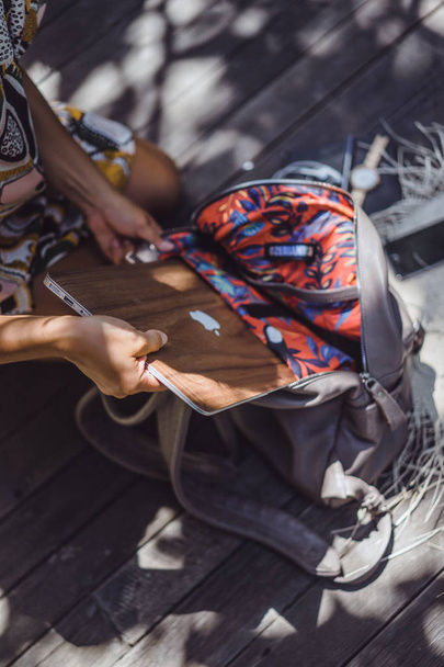 kız bir sırt çantası toplar, bir akıllı telefon koyar dizüstü bilgisayar - Fotoğraf, Görsel