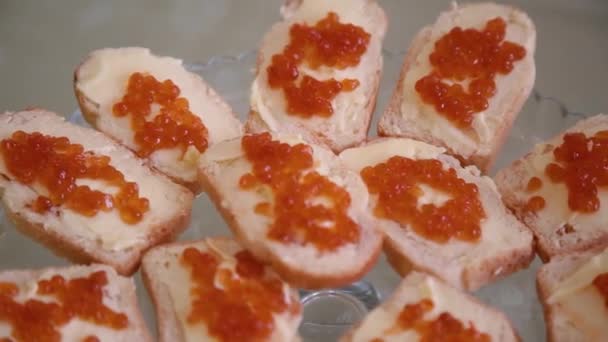 Sanduíches deliciosos com caviar vermelho em um buffet ou banquete, close-up
. - Filmagem, Vídeo