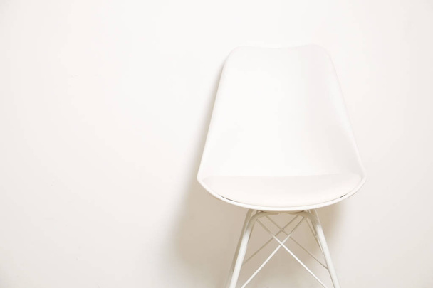 Single elegant white loft style chair standing alone in empty room, big blank wall background with a lot of copy space for your text. Only one vacant seat. Human resources hiring campaign concept. - Foto, Bild