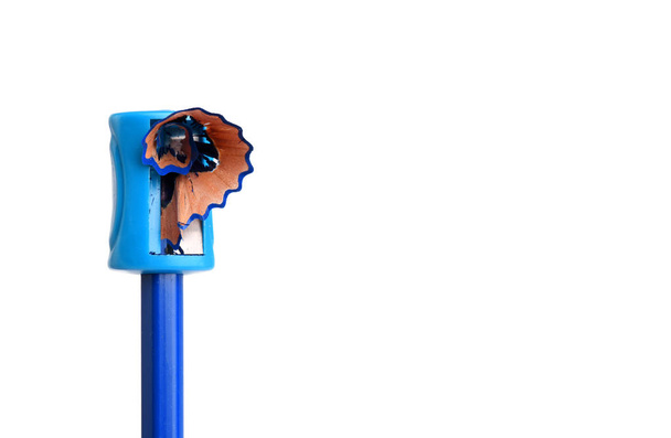 Blauwe kleurpotlood beeing geslepen met een handmatige puntenslijper  - Foto, afbeelding